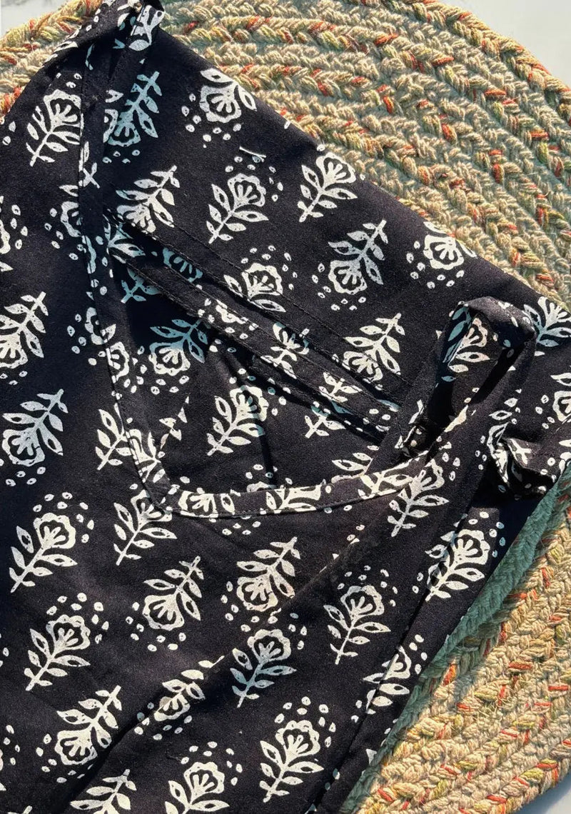 Black fabric with white floral pattern on a textured surface