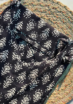 Black fabric with white floral pattern on a textured surface