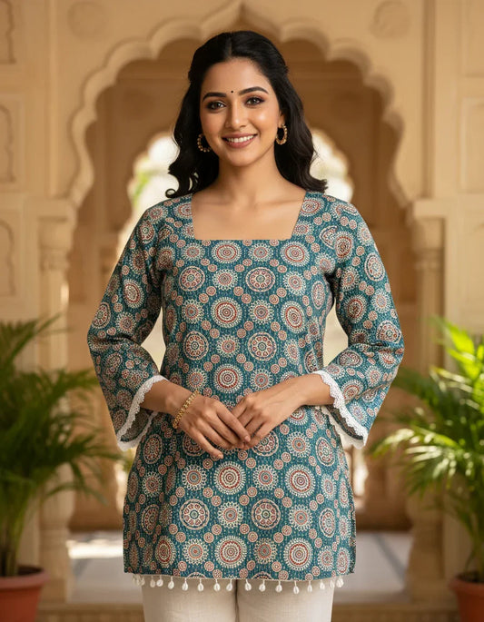 Woman wearing a patterned katha blue kurta with white trim in an ornate architectural setting.