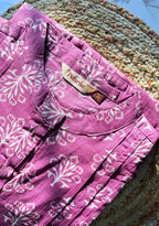 Purple floral shorts with a brand label on a textured surface