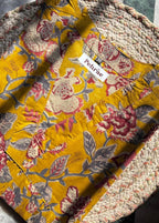 Floral-patterned fabric with a brand label on a textured surface Short Kurti